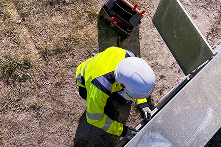 Ouvrier travaillant sur une installation électrique avec des vêtements de protection contre les arcs électriques par Tranemo
