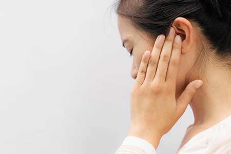 Vrouw met oorpijn grijpt naar oor