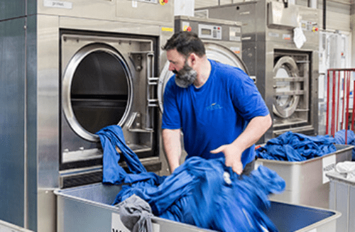 Tapis De Nettoyage De Travailleur Masculin Sur L'équipement De Machine à  Laver Automatique Et Sèche-linge Dans La Buanderie