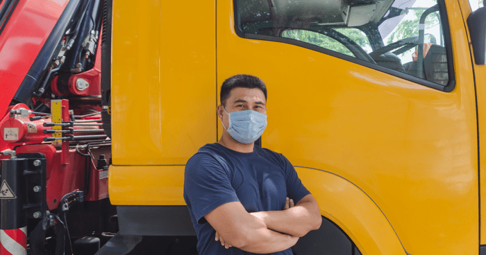 man draagt een chirurgisch mondmasker voor een vrachtwagen